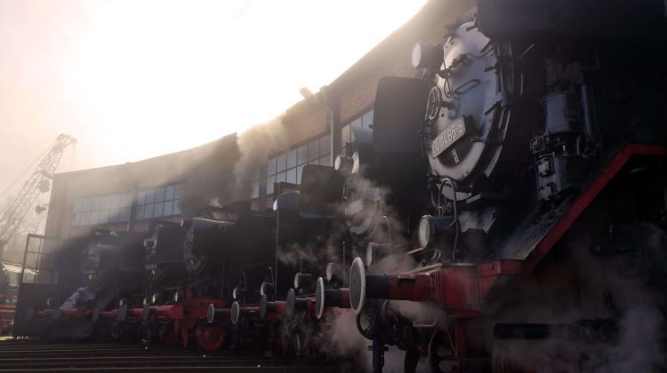 Rauchende Dampflokomotiven vor einem Bahnhof